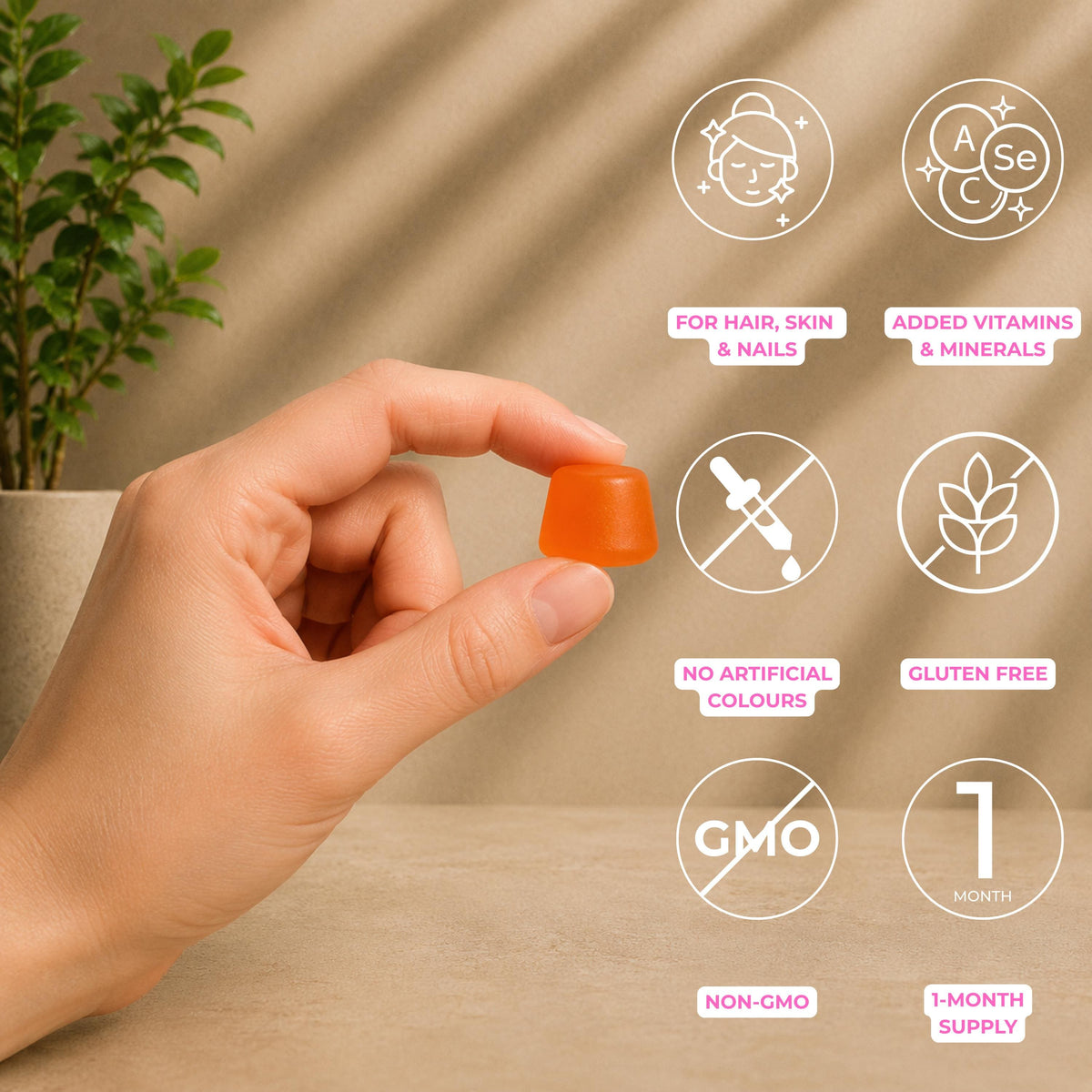 A hand holds a small translucent orange capsule-shaped supplement pill against a warm beige background with soft leaf shadows. White circular icons with pink text highlight product benefits: for hair, skin, and nails; added vitamins and minerals; no artificial colors; gluten free; non-GMO; and a 1-month supply.